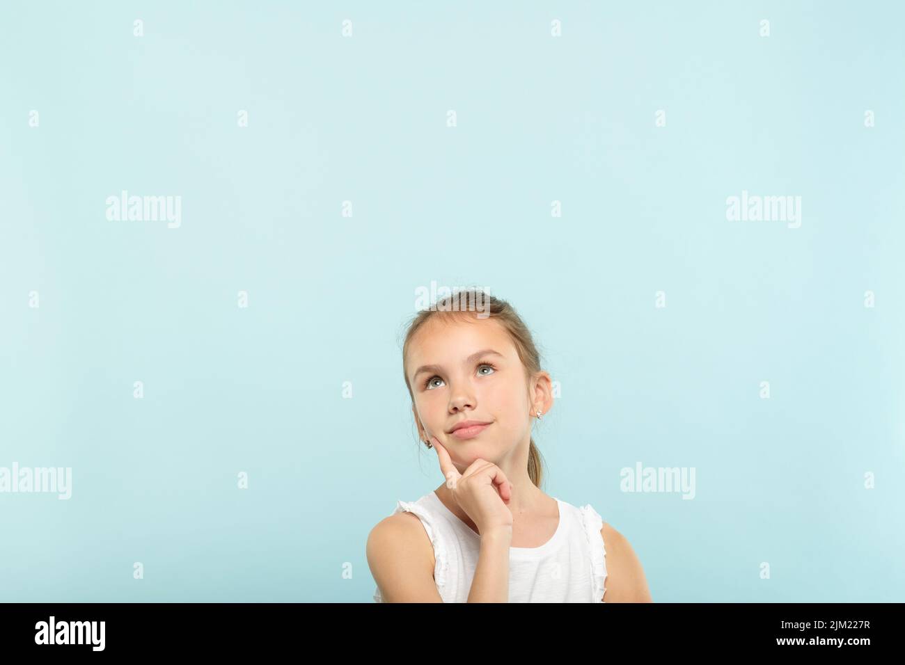 smiling dreamy girl look up advertising space Stock Photo