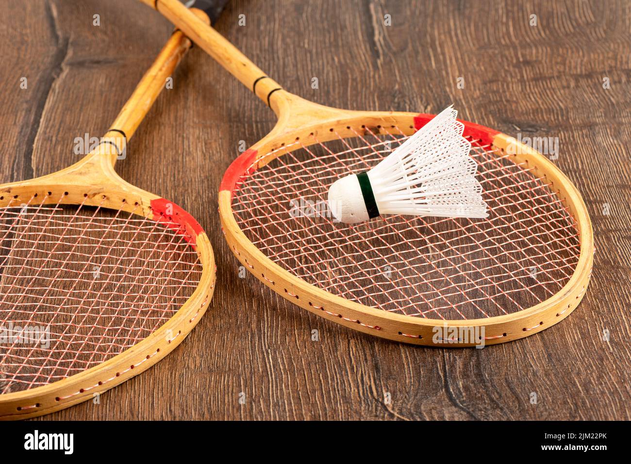 Plastic shuttlecock on one of two badminton rackets. Outdoor games Stock Photo Alamy