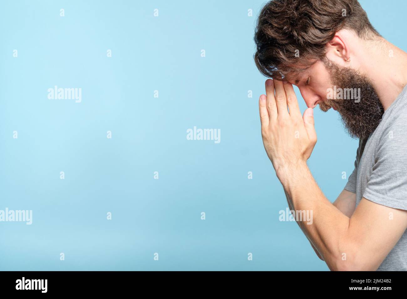 man pray hands forehead spirituality faith belief Stock Photo