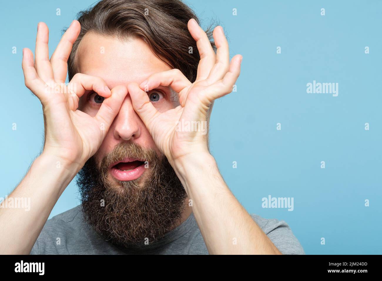 funny comic playful man look hand binocular Stock Photo Alamy