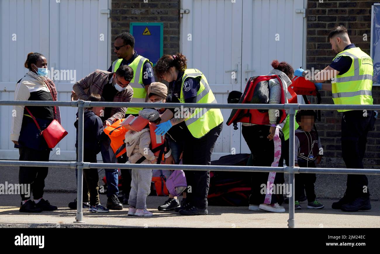 EDITORS NOTE Children's faces have been pixelated as the PA Picture Desk has been unable to gain the necessary permission to photograph a child under 16 on issues involving their welfare. A group of people thought to be migrants are brought in to Dover, Kent, following a small boat incident in the Channel. Picture date: Thursday August 4, 2022. Stock Photo