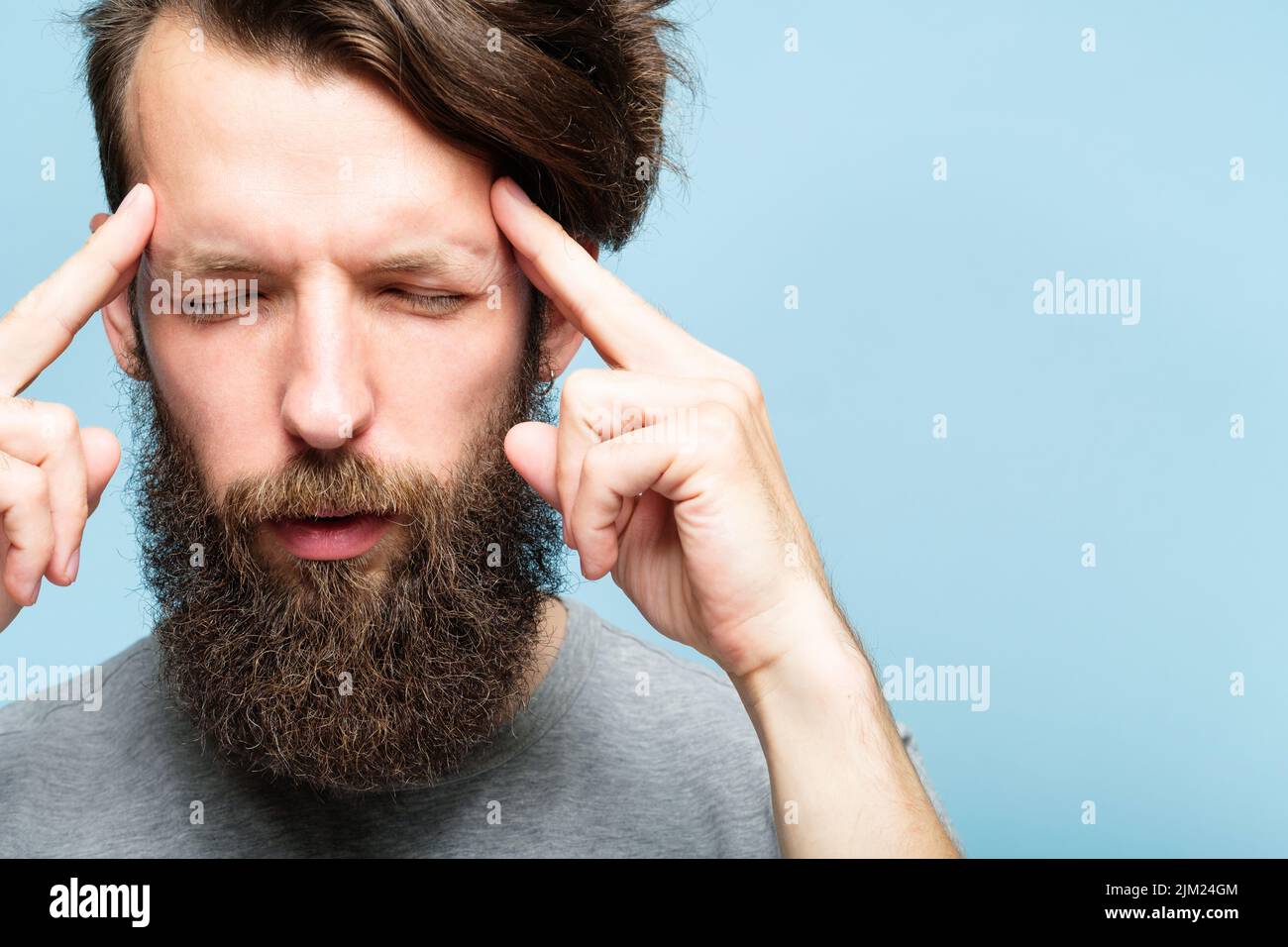 headache fatigue emotional stress man temples Stock Photo