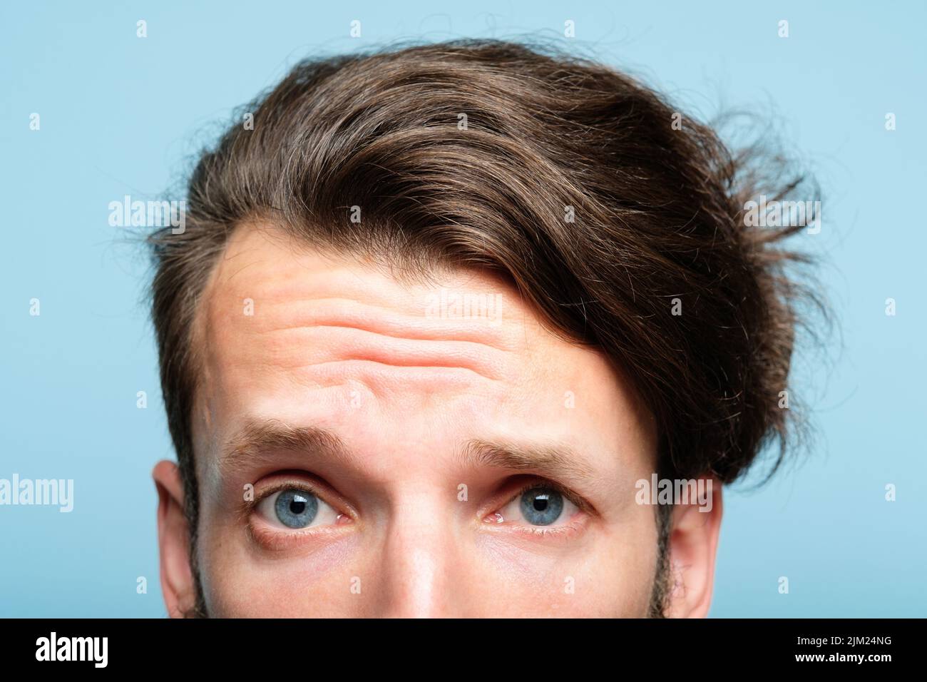 suspicious dubious man skeptic look peep out Stock Photo