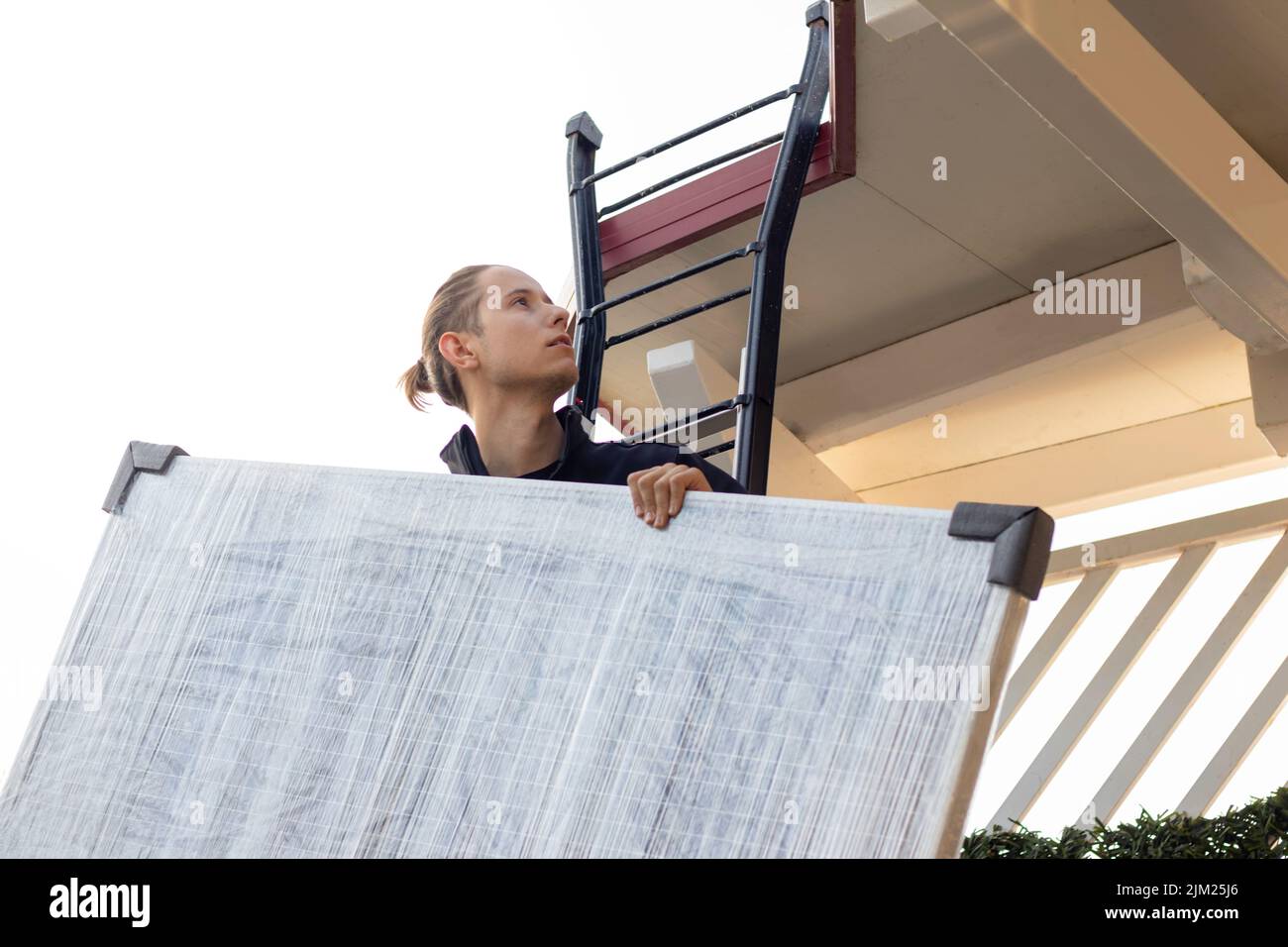 Young man worker installing a solar panel for eco energy at home and avoid global warming Stock Photo