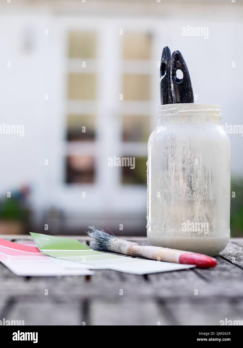 Paint brushes in pot outside house Stock Photo
