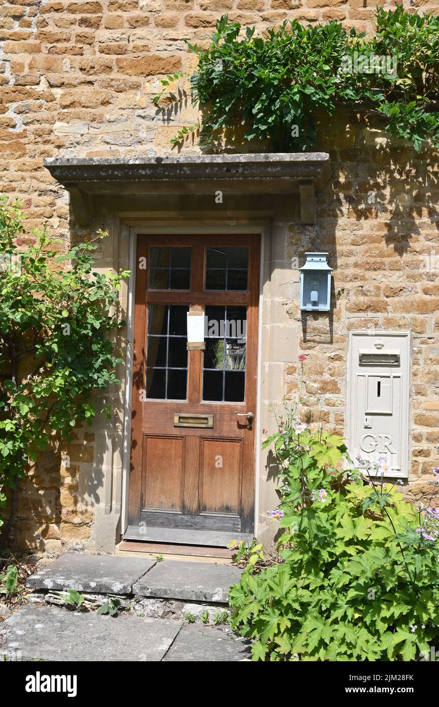 A disused George V postbox is set into the front wall of a house in the Gloucestershire hamlet of Adlestrop Stock Photo