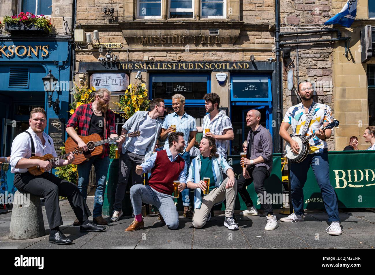 Edinburgh, Scotland, United Kingdom, 4th August 2022. Edinburgh Festival Fringe: The Chior of Man all male singong grup appearing at the Fringe this month enjoy a pint and a sing song at the Smallest Pub in Scotland in the Grassmarket before their appearance later today. Credit: Sally Anderson/Alamy Live News Stock Photo