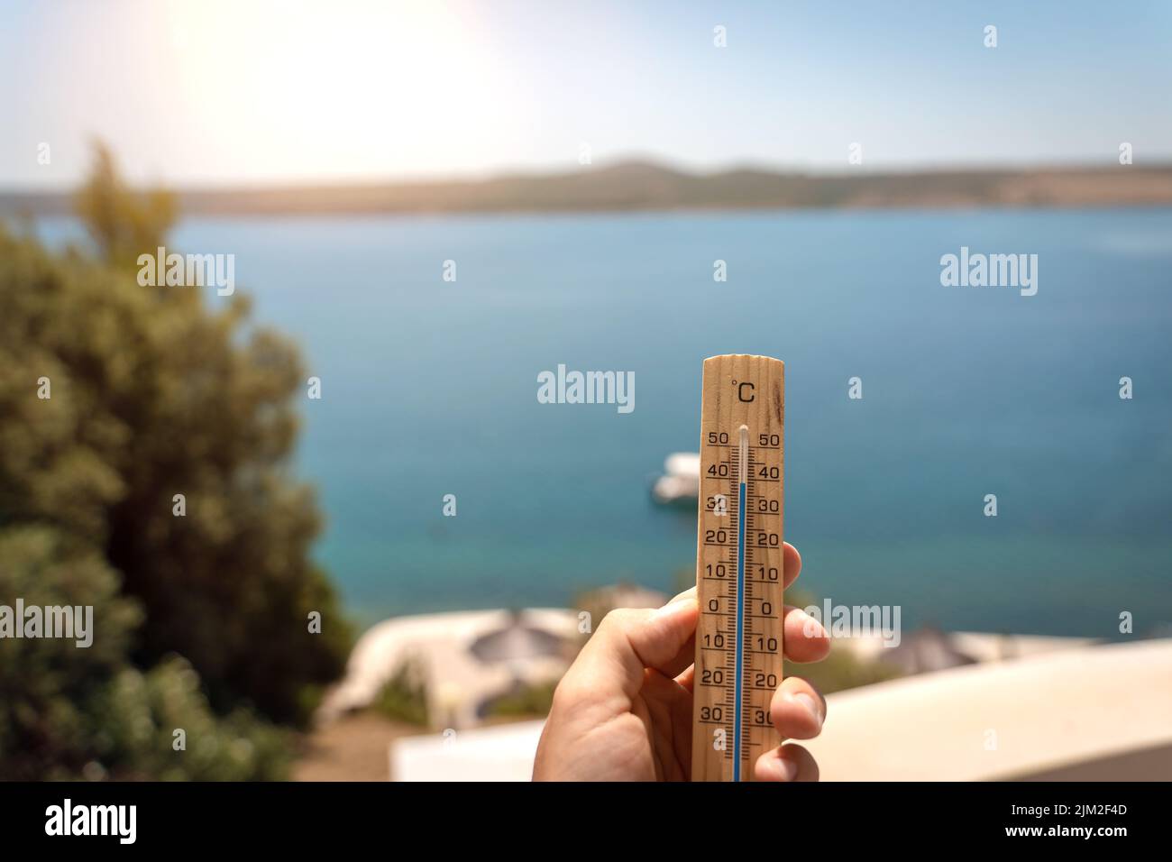 A Male Hand Holds A Wooden Thermometer With 40 Degrees Celsius In The Sky In Sunshine, Symbol Image High Temperature In Summer With Heat Wave Stock Photo