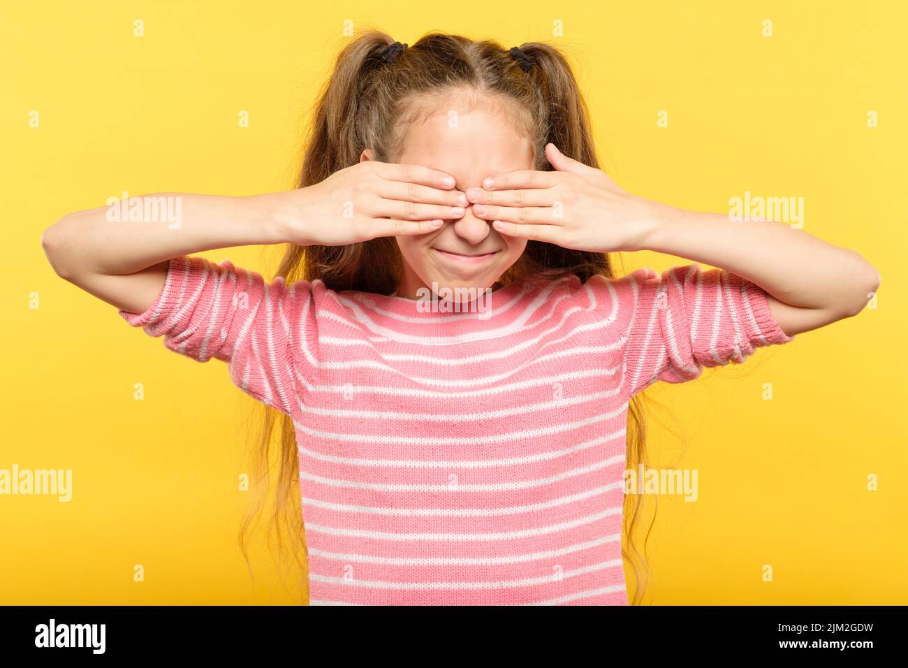 see no evil smiling girl covering eyes hands Stock Photo