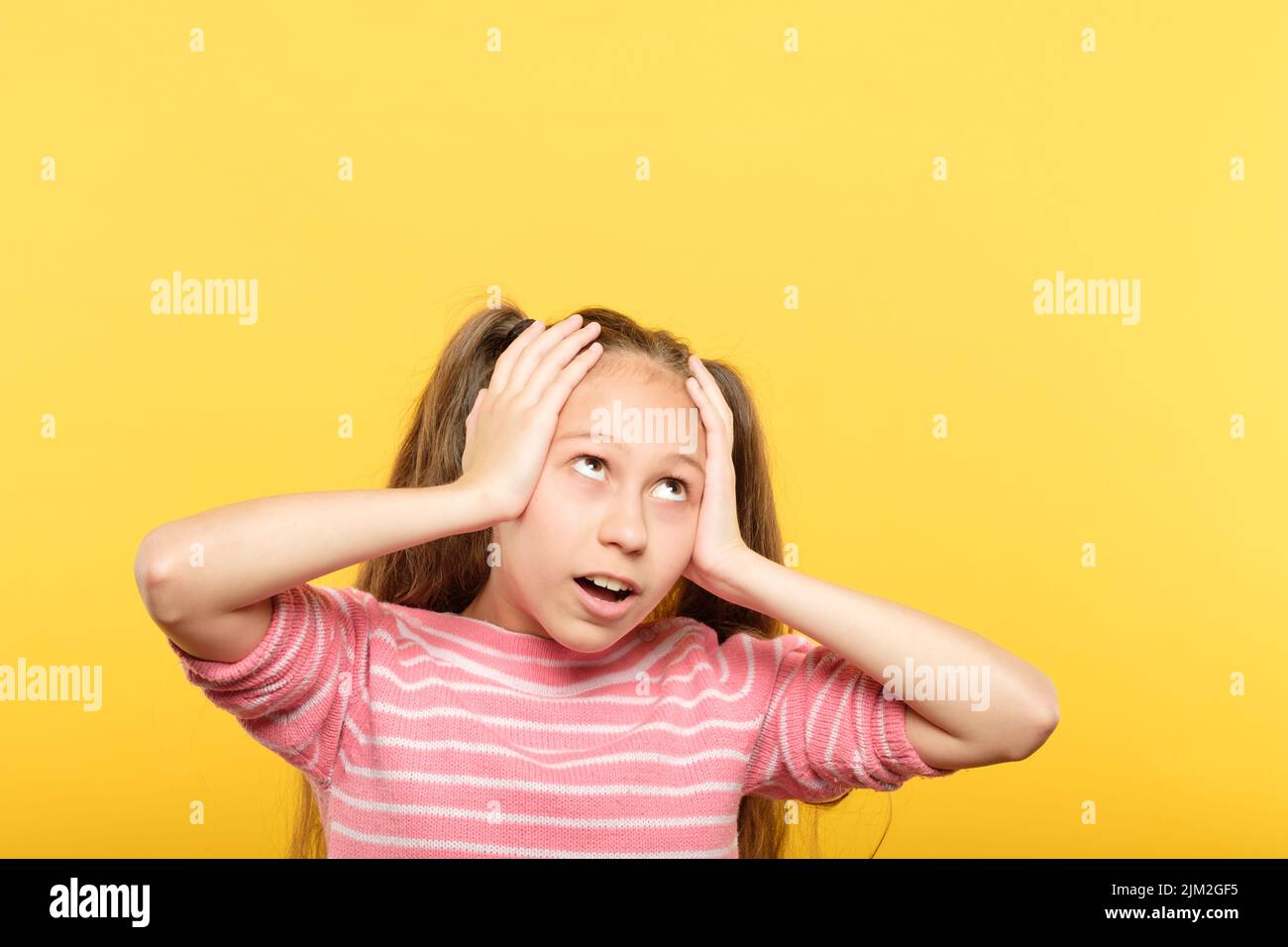 omg shocked girl looking up grasping head hands. Stock Photo