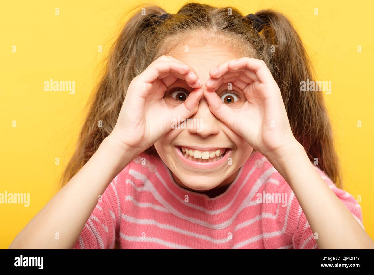 funny joyful playful girl look hand binoculars Stock Photo Alamy