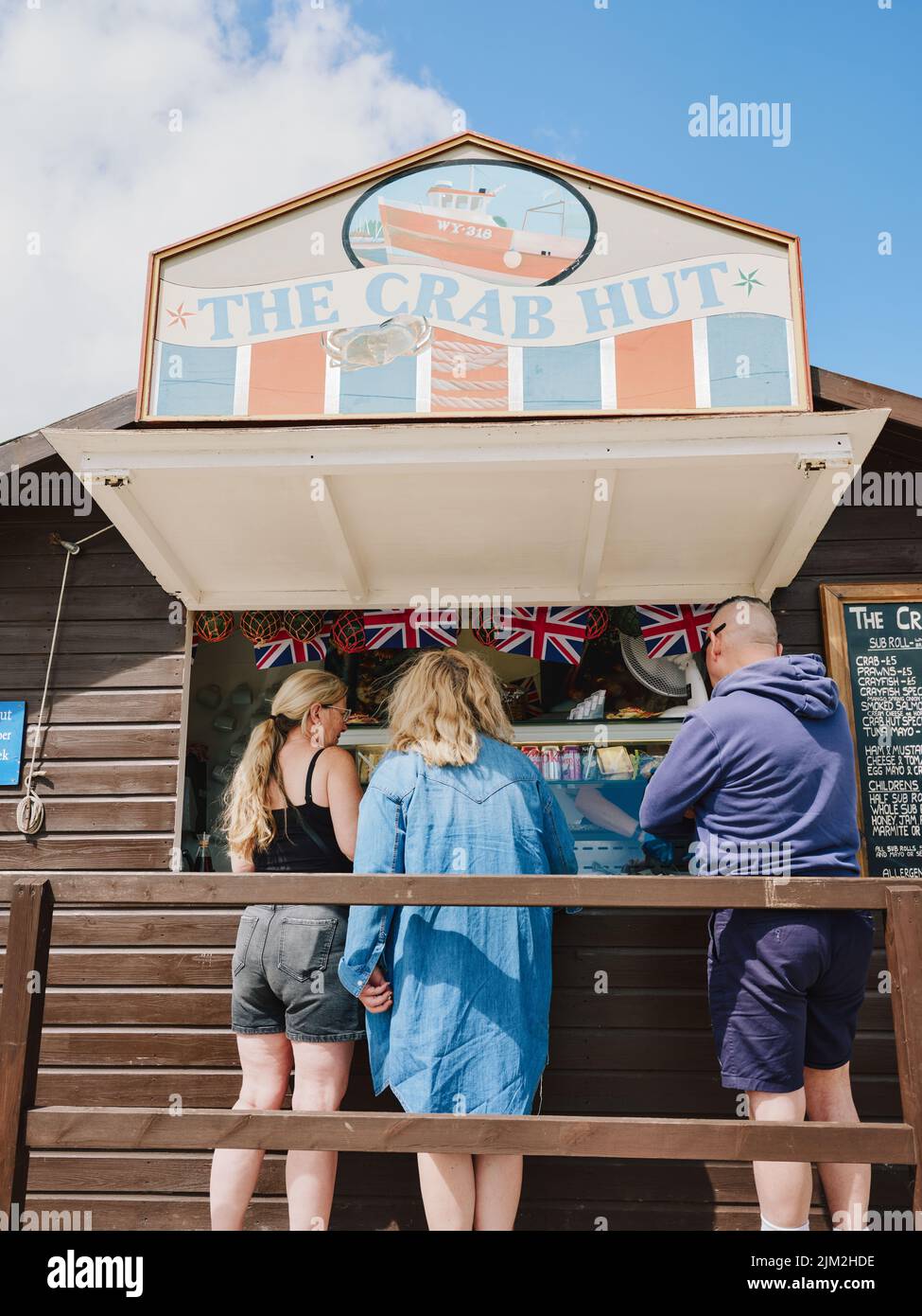Customers on a sunny day at a Crab Hut selling fresh local seafood in