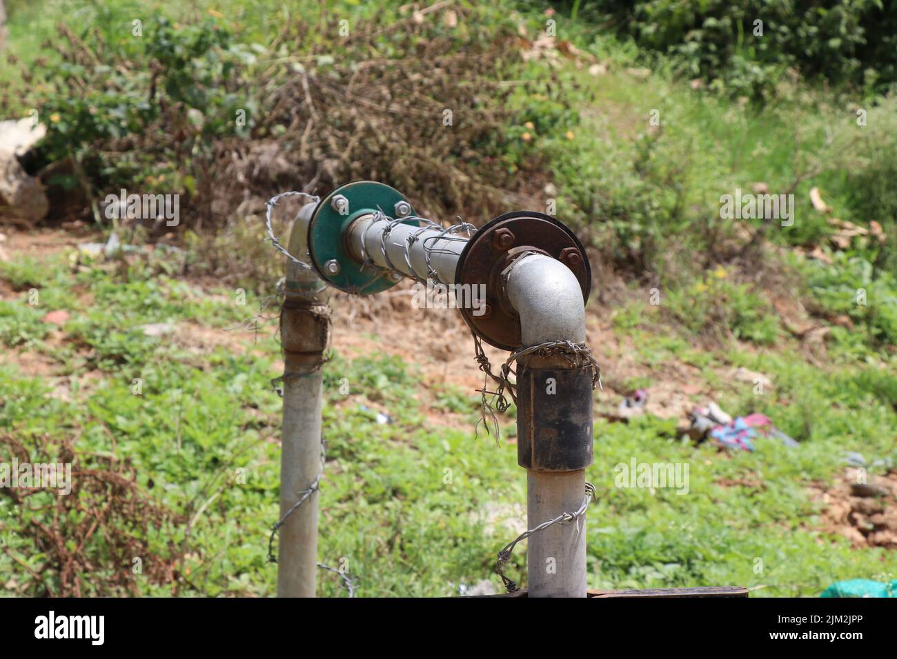 Old submersible or underground water pump connected with metal pipes to transport water to places Stock Photo