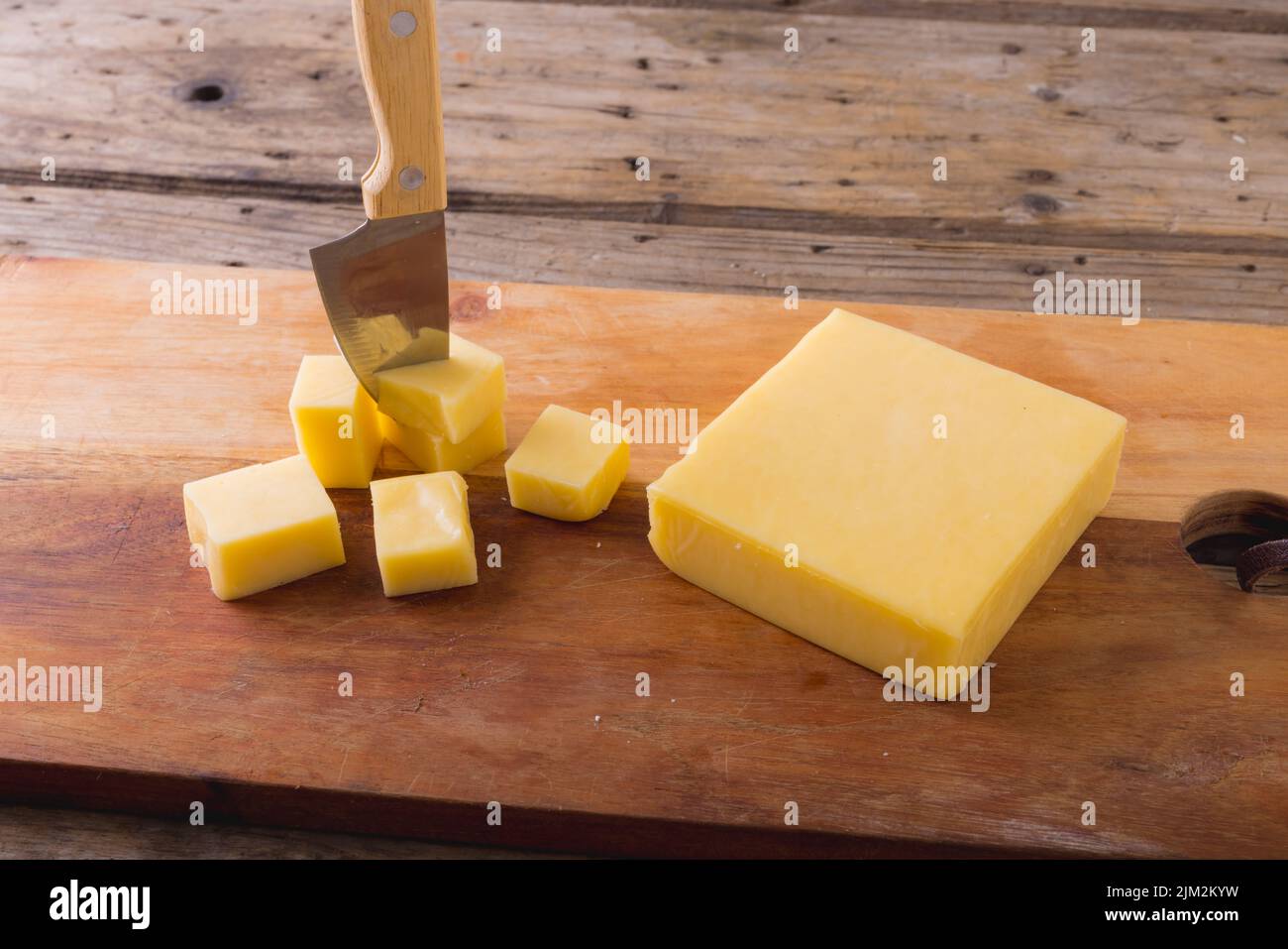 High angle view of cheese with knife on board at table, copy space. unaltered, food and dairy product. Stock Photo