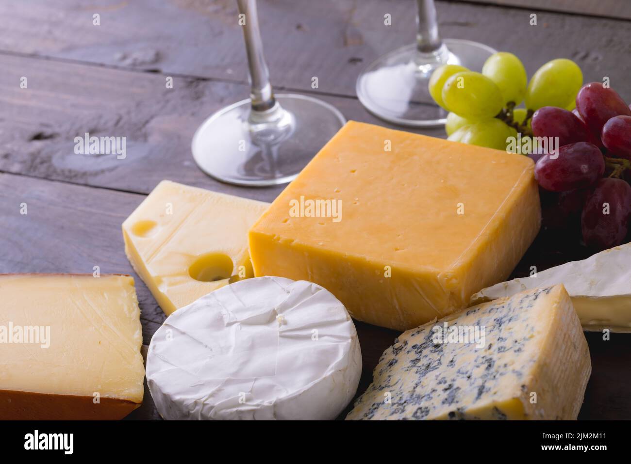 High angle view of various cheese with grapes on table, copy space. unaltered, food, fruit and dairy product. Stock Photo