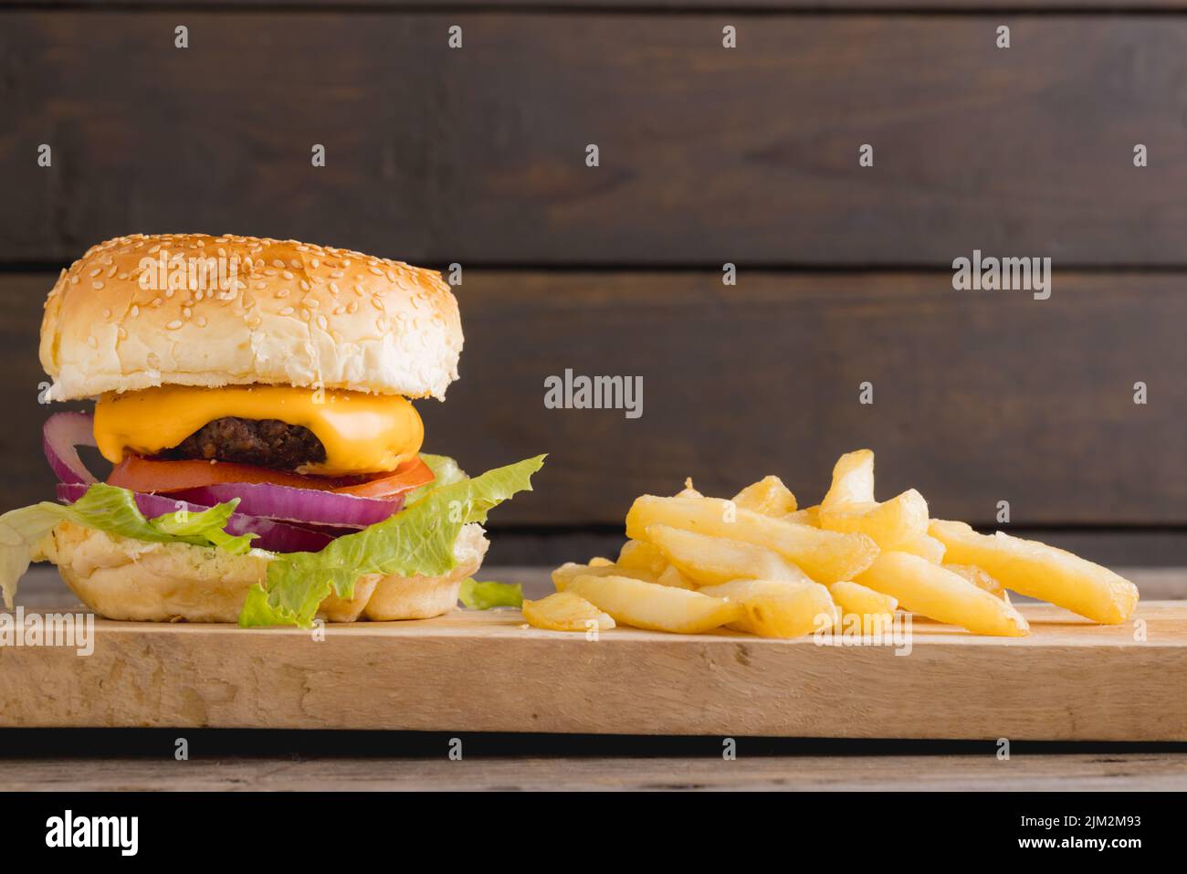 Close-up of burger with french fries on wooden board, copy space Stock Photo