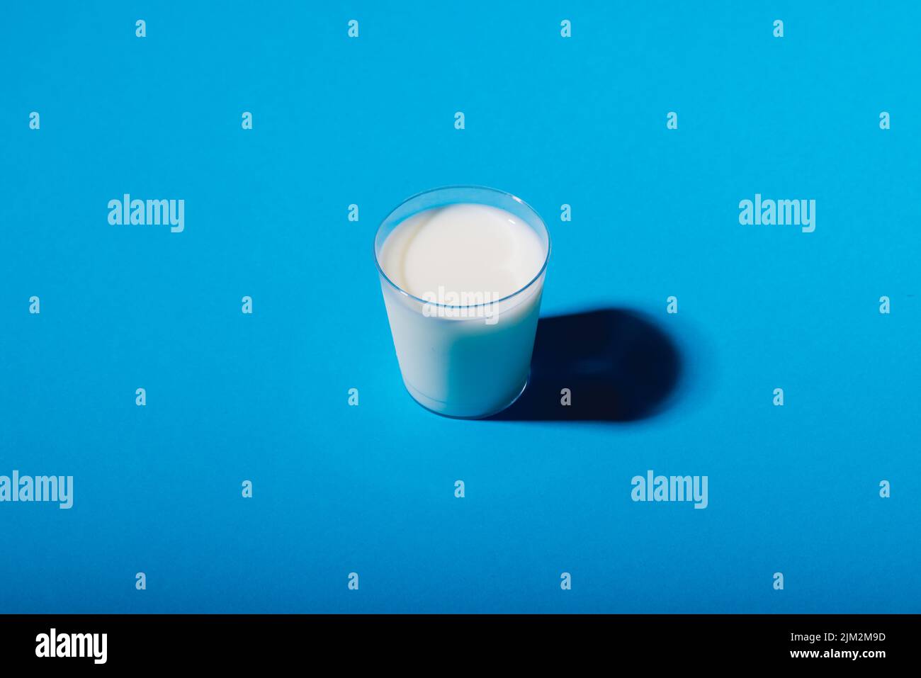 High angle view of milk glass on blue background, copy space. unaltered, food, drink, studio shot and healthy food concept. Stock Photo