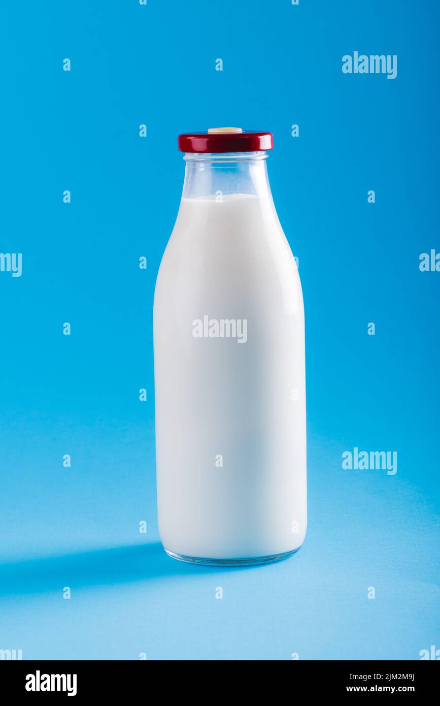 Close-up of milk bottle against blue background, copy space. unaltered, food, drink, studio shot and healthy food concept. Stock Photo