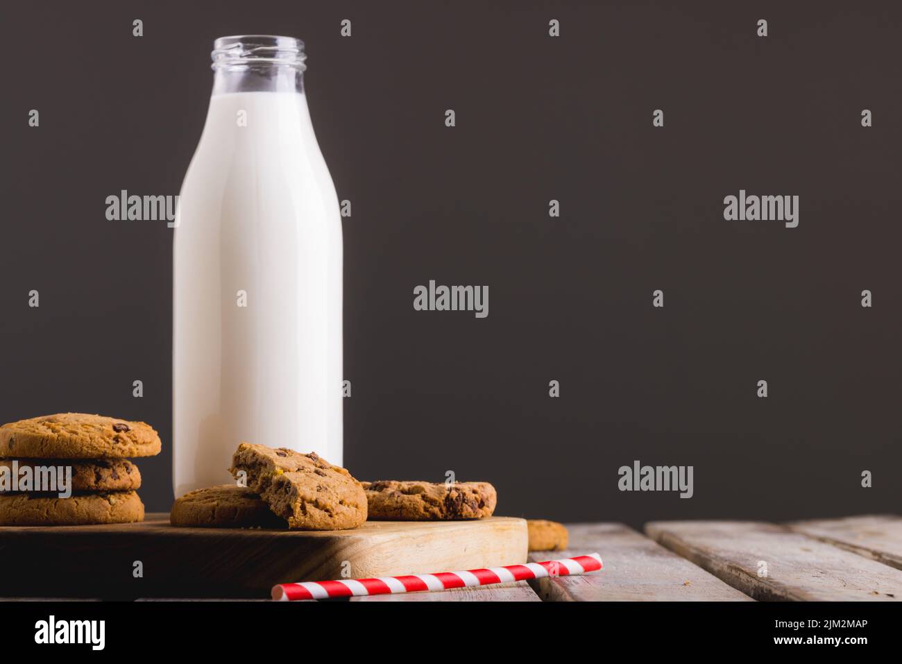 Milk bottle with cookies on table against gray background, copy space. unaltered, food, drink, studio shot and healthy food concept. Stock Photo