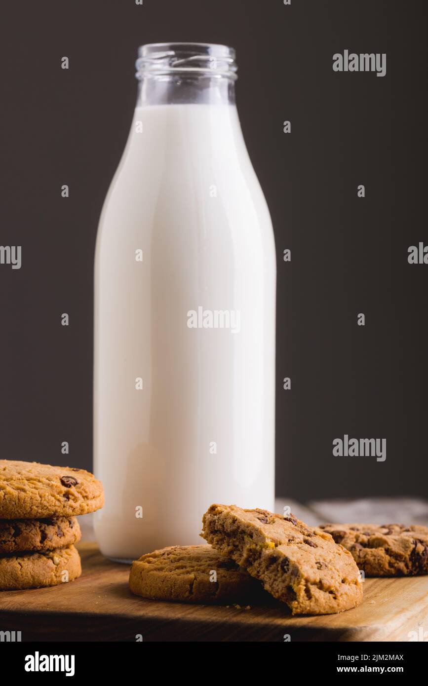 Close-up of milk bottle with cookies on table against gray background, copy space. unaltered, food, drink, studio shot and healthy food concept. Stock Photo