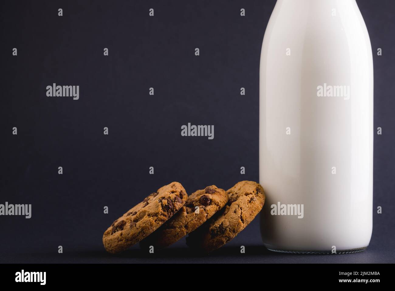 Cookies with milk bottle against gray background, copy space. unaltered, food, drink, studio shot and healthy food concept. Stock Photo