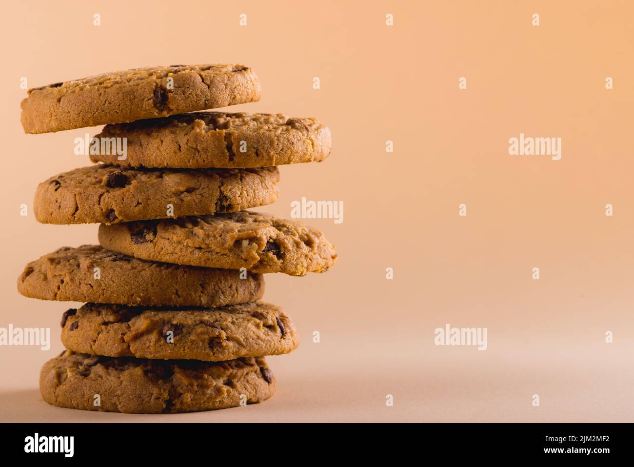 Close-up of stack of cookies against brown background with copy space. unaltered, food, baked, studio shot and snack. Stock Photo