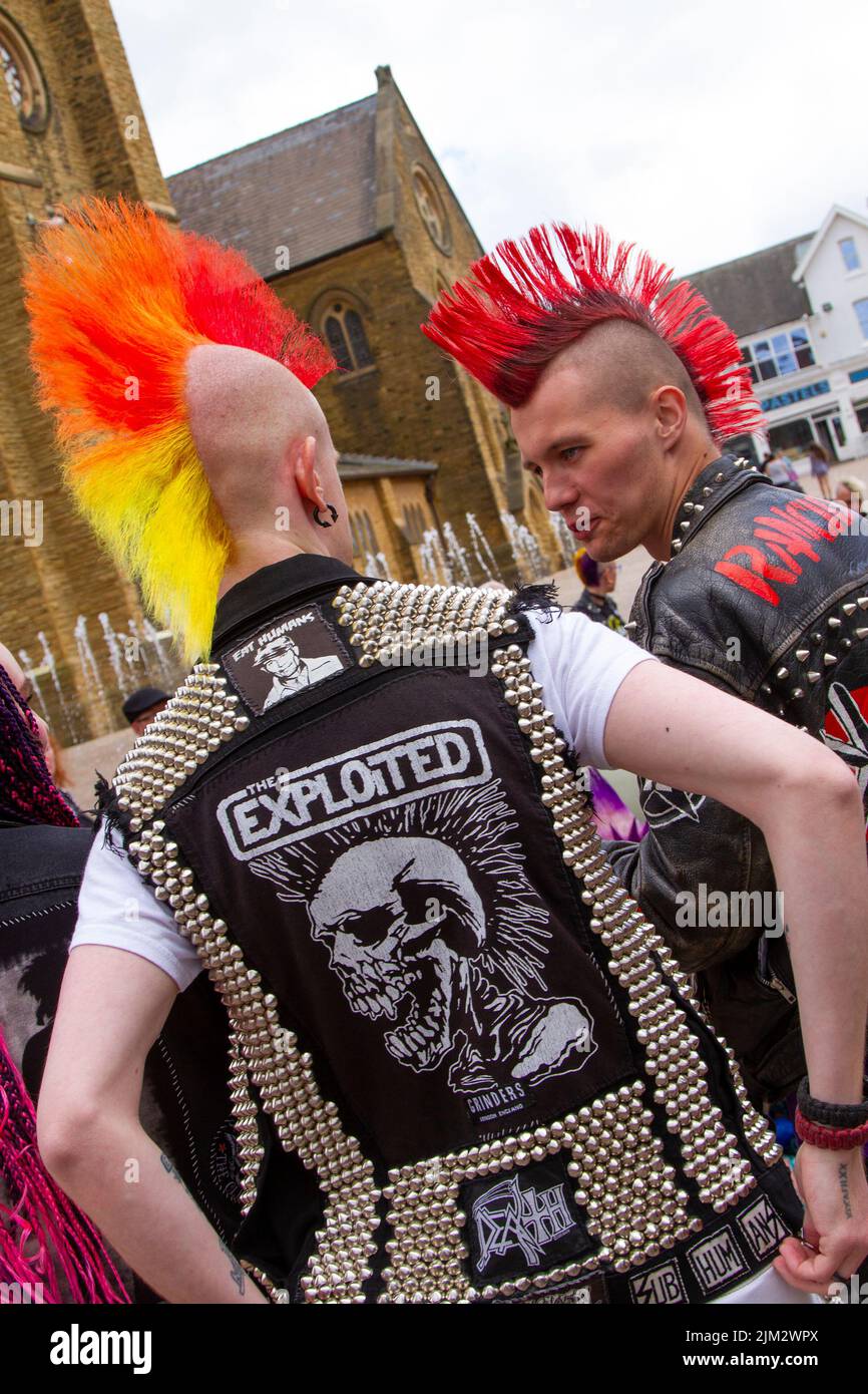 Punk Rocker wearing heavy metal leather spiked jacket in Blackpool, Lancashire, UK. 4th Aug 2022. The punk subculture, ideologies, fashion, with Mohican dyed hairstyles and colouring at the Punk Rebellion festival at The Winter Gardens. A protest against conventional attitudes and behaviour, a clash of anti-establishment cultures,  mohawks, safety pins and a load of attitude at the seaside town as punks attending the annual Rebellion rock music festival at the Winter Gardens come shoulder to shoulder with traditional holidaymakers.  Credit: MediaWorldimages/AlamyLiveNews Stock Photo