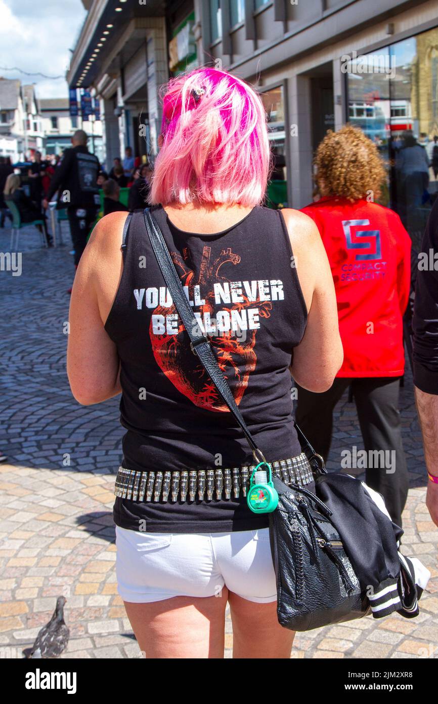 Woman wearing Bullet Belt, Rock belt, Metal belt, Gothic belt in Blackpool, Lancashire, UK. Aug 2022. The punk subculture, ideologies, fashion, with Mohican dyed hairstyles and colouring at the Punk Rebellion festival at The Winter Gardens. A protest against conventional attitudes and behaviour, a clash of anti-establishment cultures,  mohawks, safety pins and a load of attitude at the seaside town as punks attending the annual Rebellion rock music festival at the Winter Gardens come shoulder to shoulder with traditional holidaymakers.  Credit: MediaWorldimages/AlamyLiveNews Stock Photo