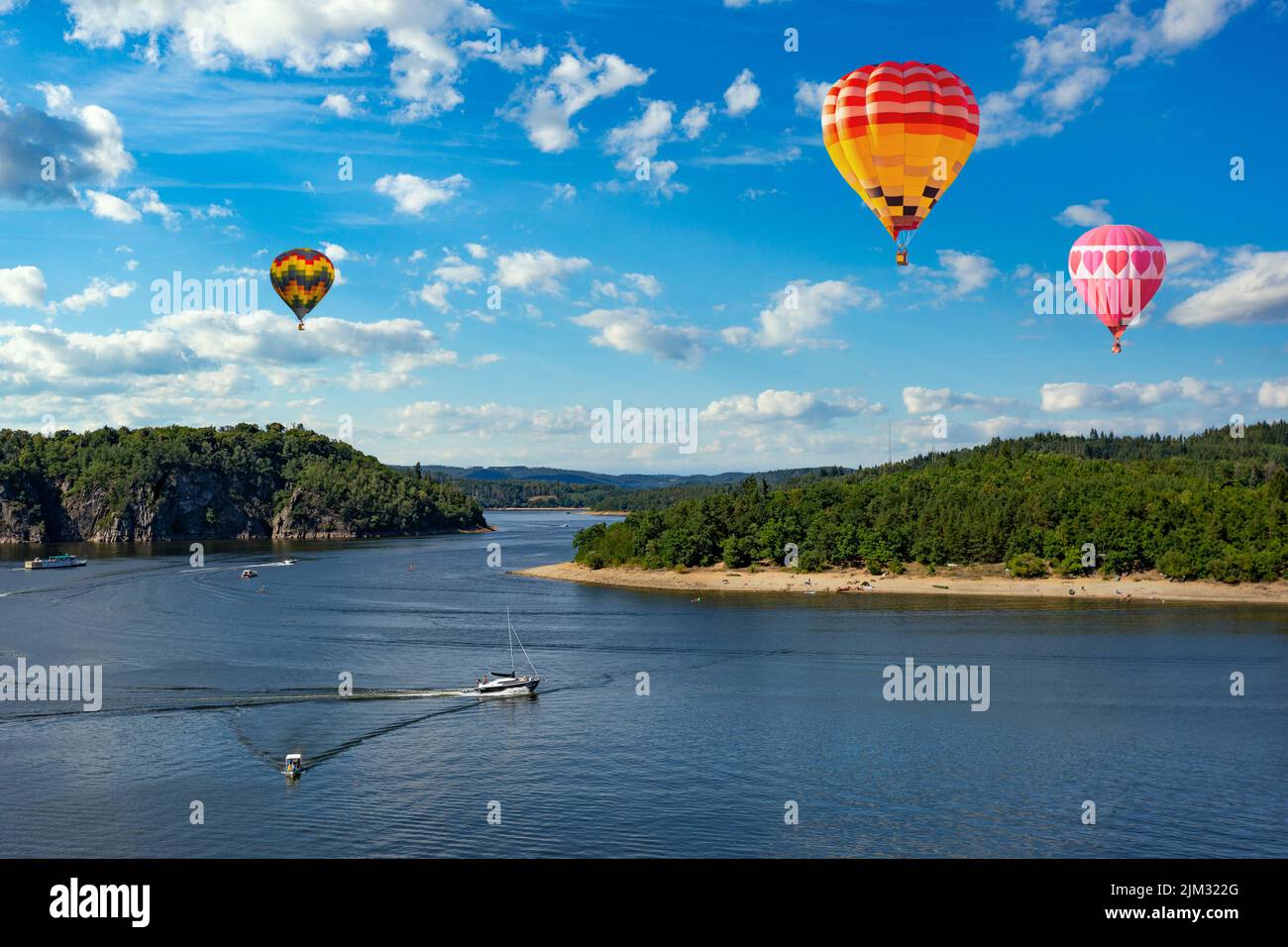 Hot air balloons in the sky over Vltava river near Orlik castle. Czechia Stock Photo