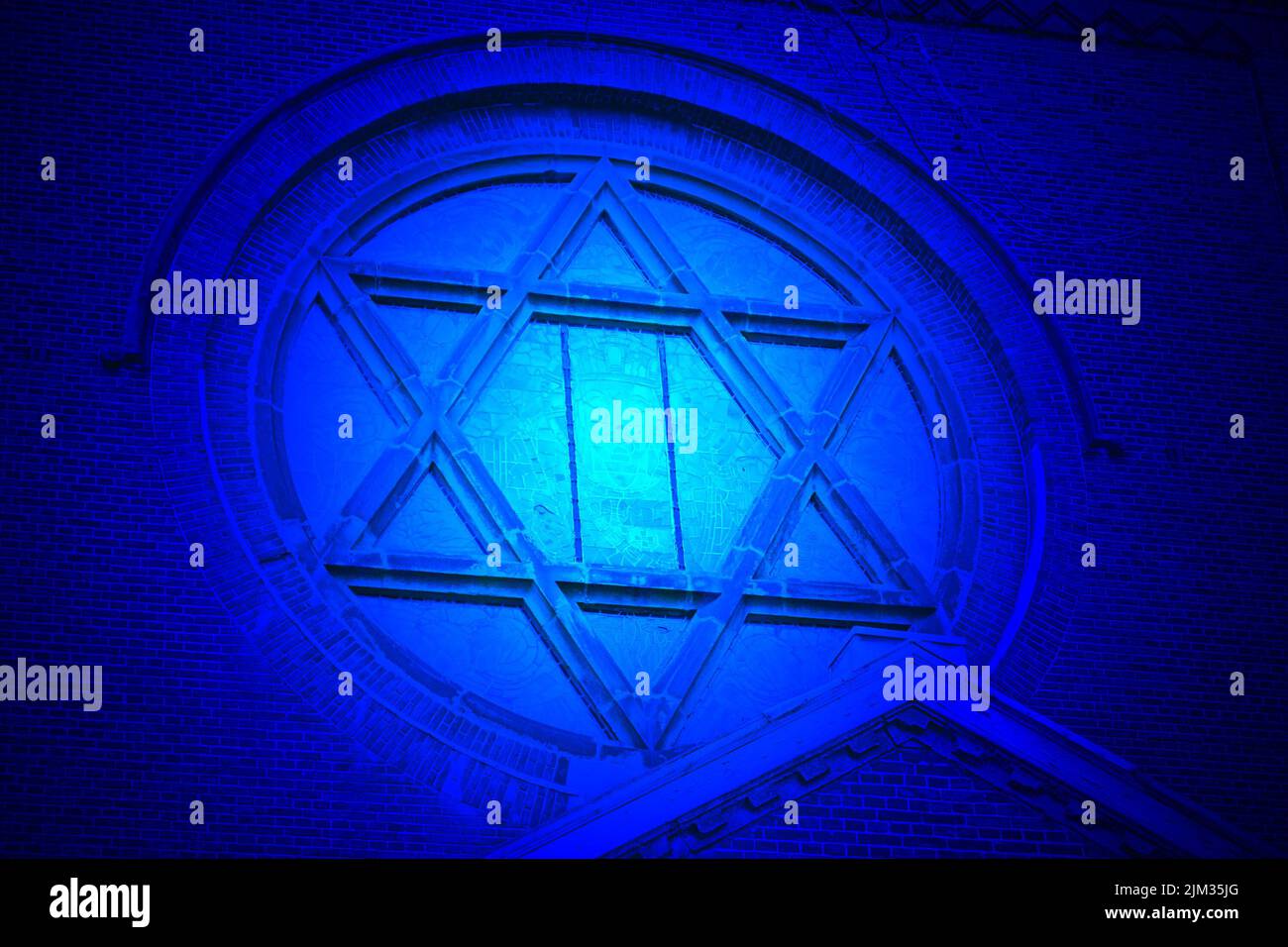 magic blue light over jewish star on vintage church, old stone wall ...