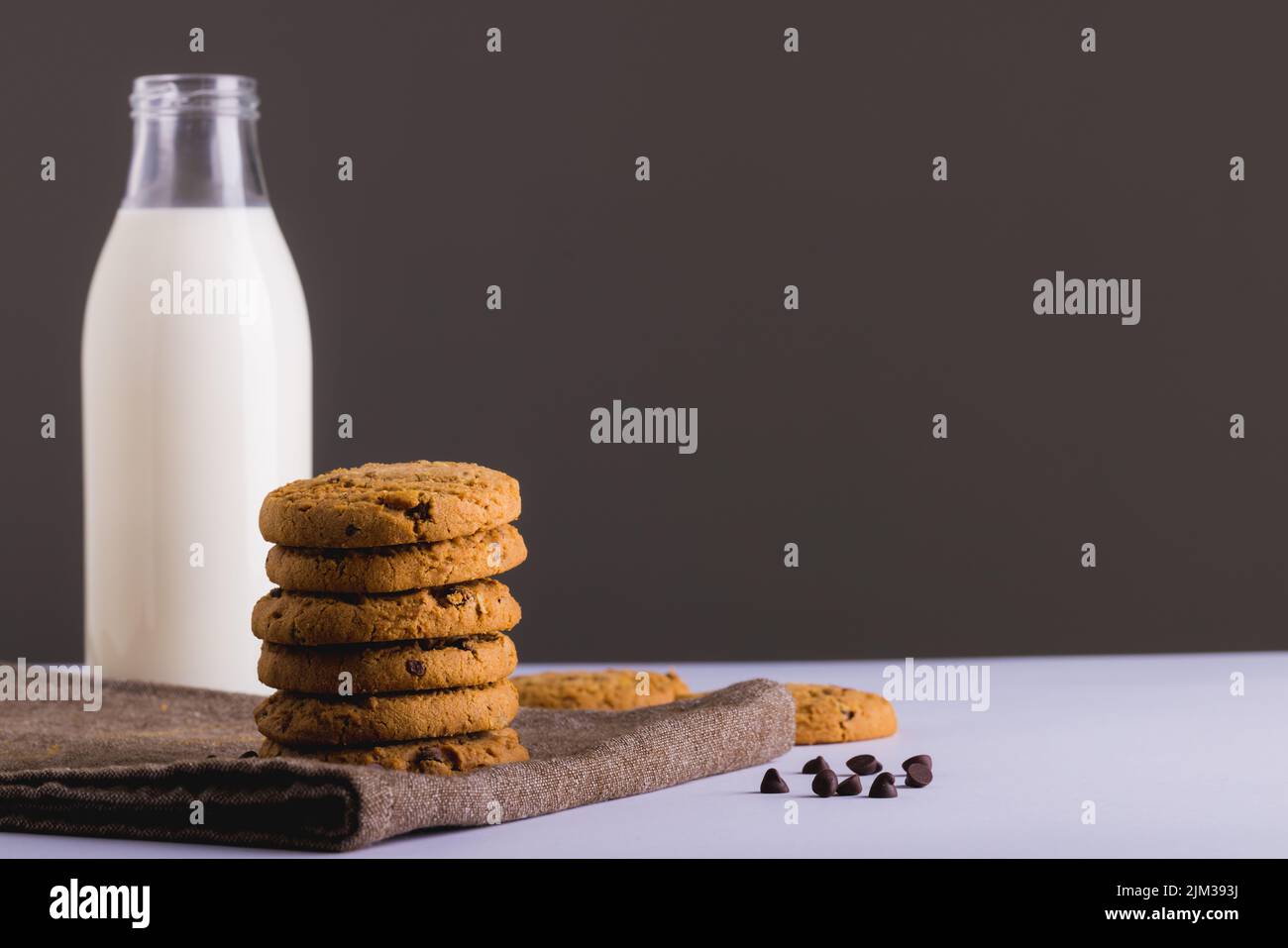 Milk in glass bottle with cookies against gray background, copy space. unaltered, food, drink, studio shot and healthy food concept, Stock Photo