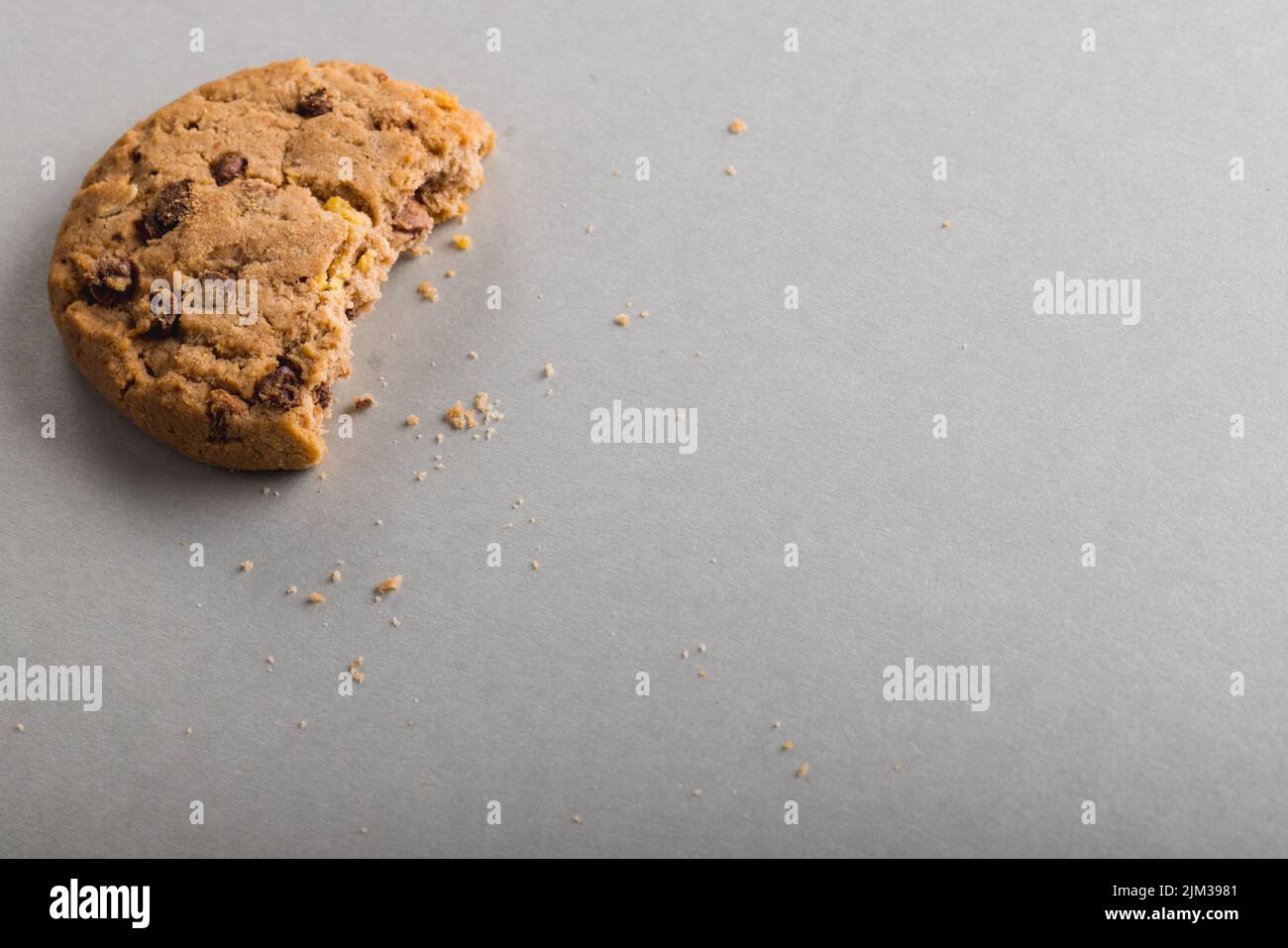 High angle view of half eaten cookie on gray background with copy space. unaltered, food, still life, studio shot. Stock Photo