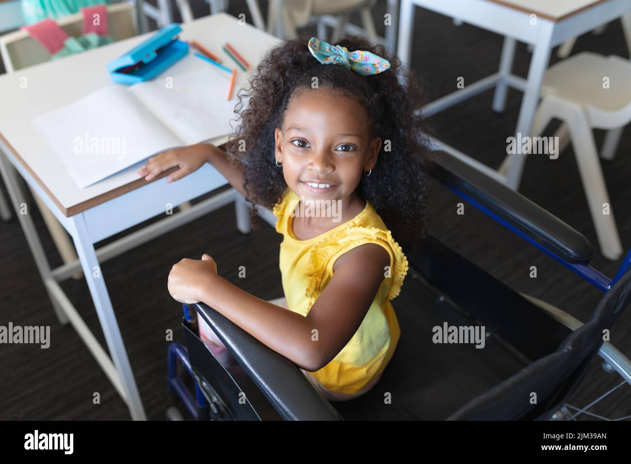 High angle portrait of smiling african american elementary girl sitting ...