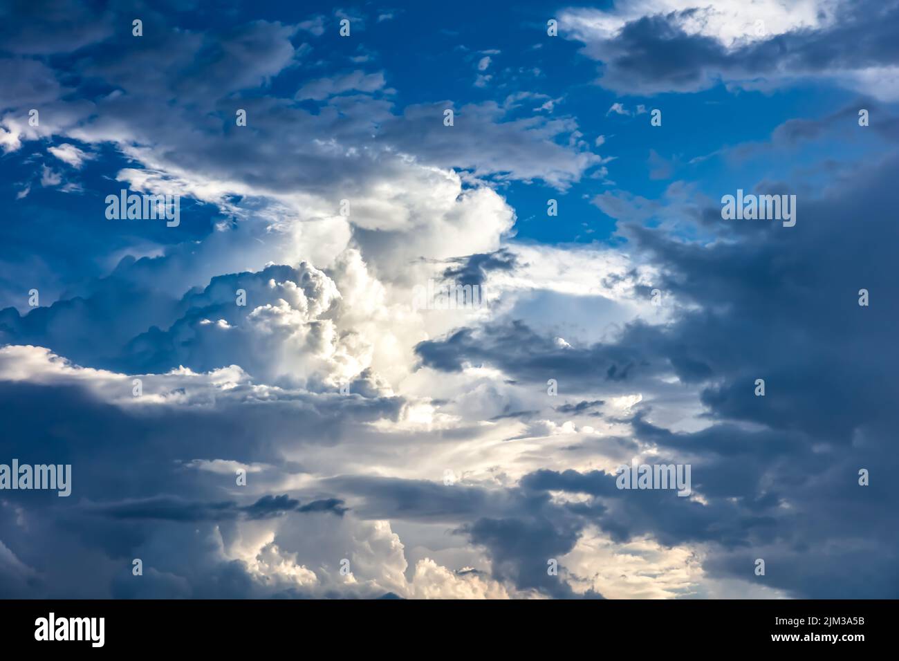 Angry, stormy cloudscape with cumulus and other cloud types. Light and dark cloud formations. Patch of blue sky. Stock Photo