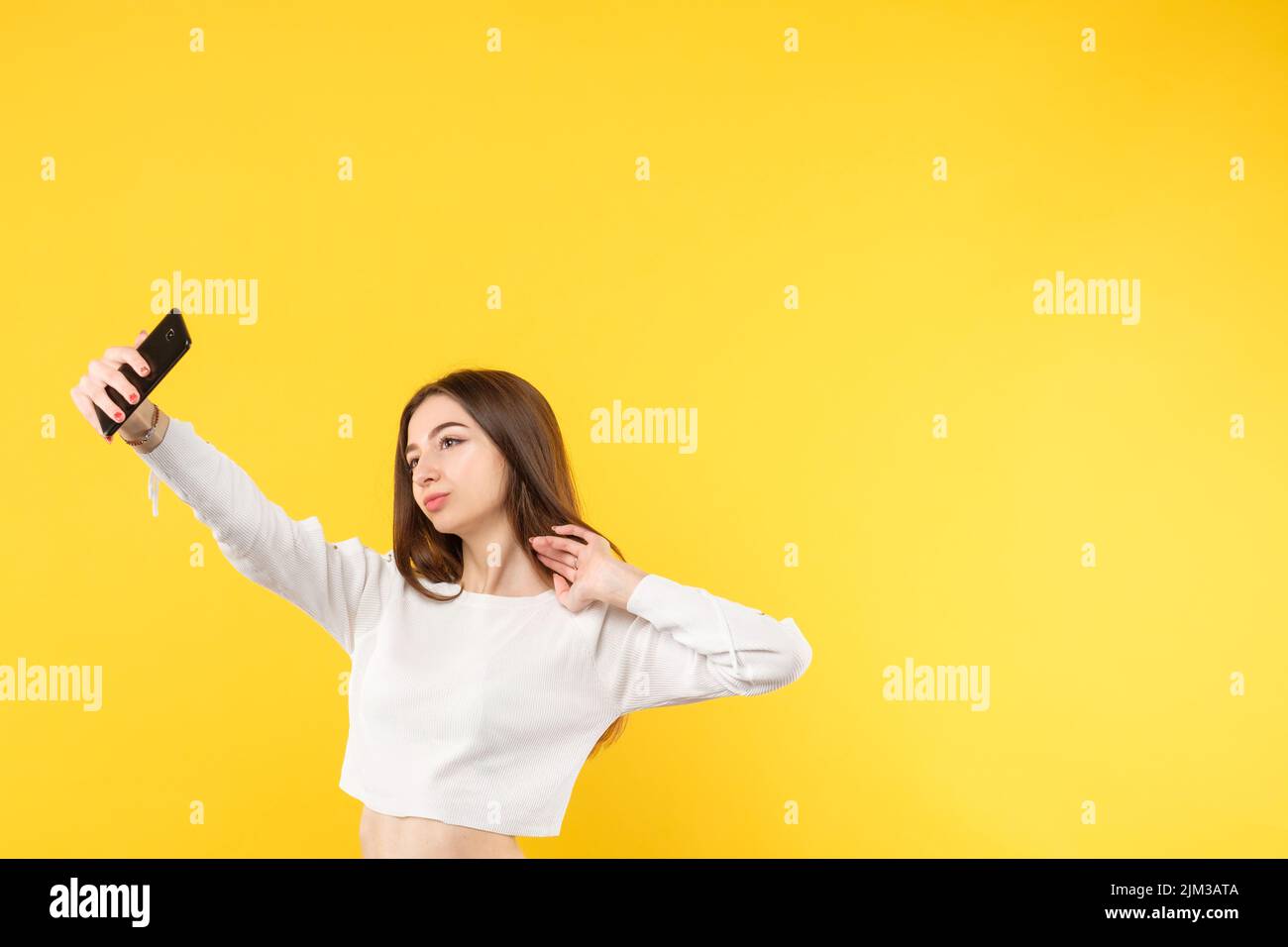woman selfie trends millennial lifestyle yellow Stock Photo