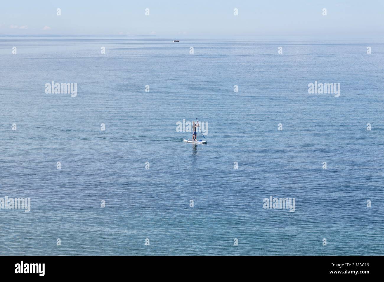 A man paddle boarding in the sea. Health,fitness,holiday, recreation, time alone concept. Stock Photo