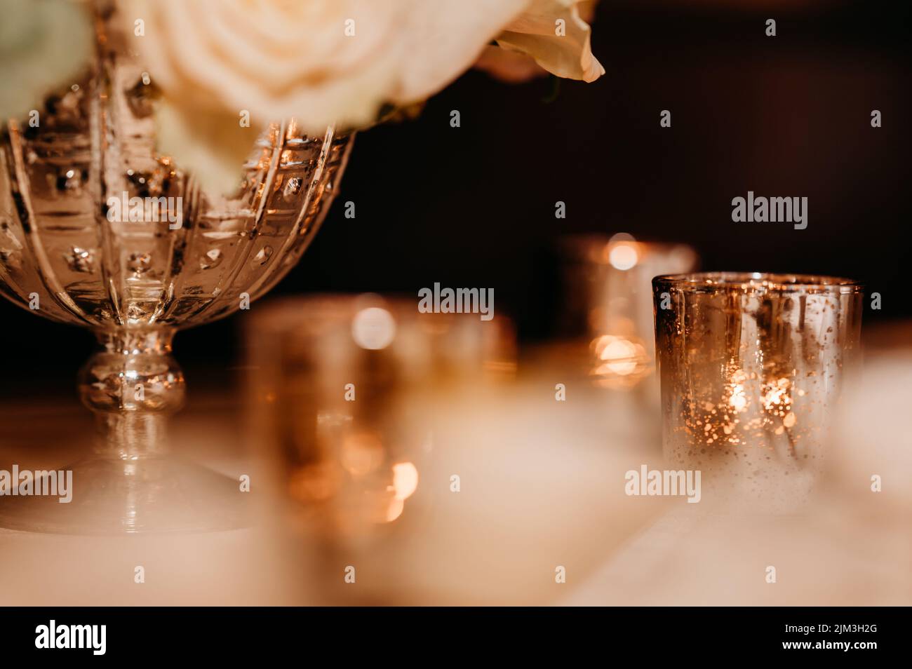 A shallow focus shot of an ornamented golden vase and glass cups Stock Photo