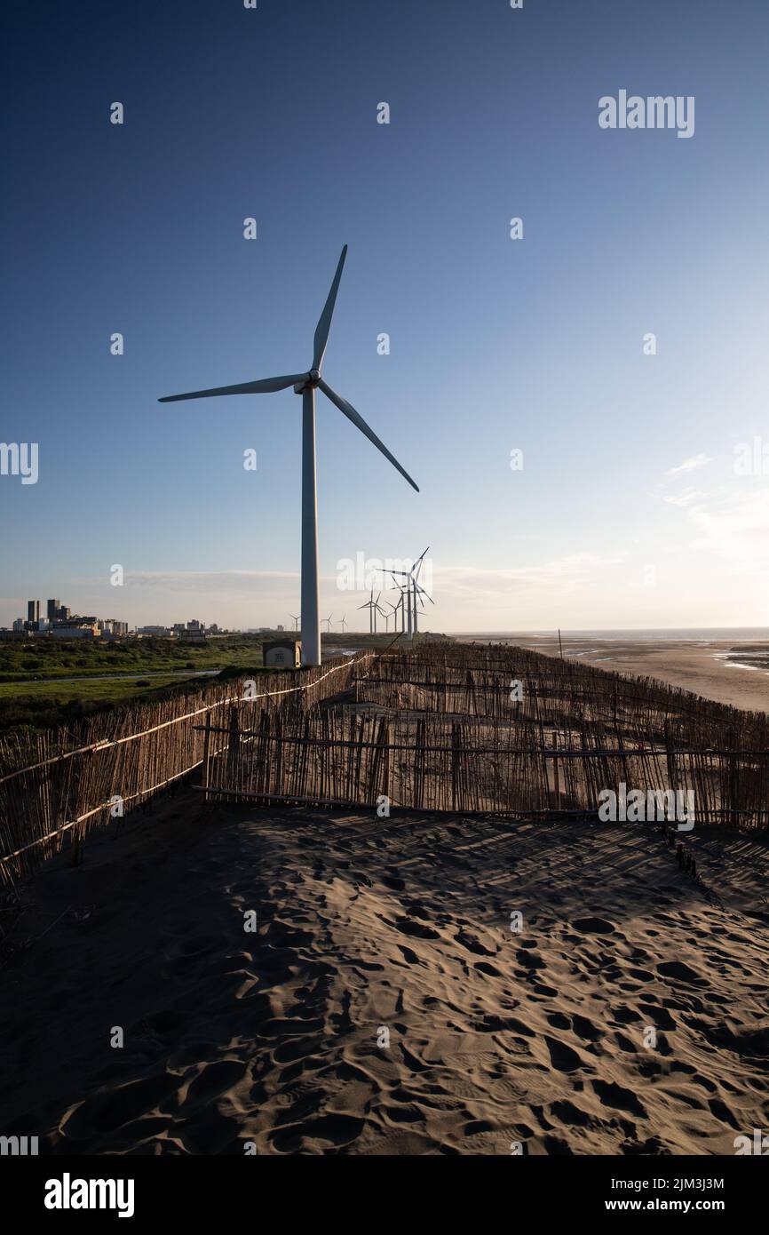 A vertical shot of a row of wind turbines on Caota dune beach in Taiwan ...