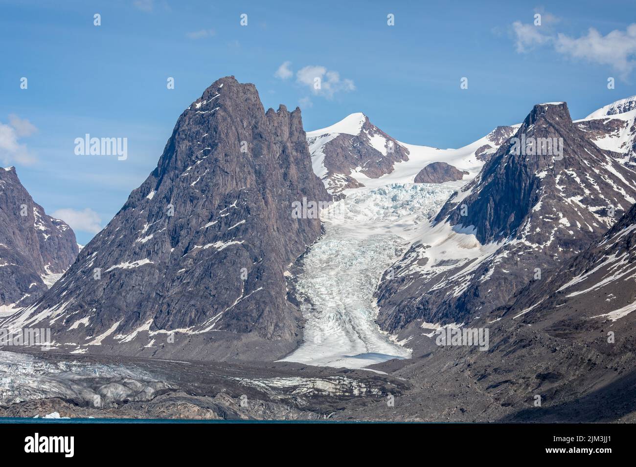 Large glacier flowing down mountain side to the sea at Evighedsfjord, Greenland Stock Photo
