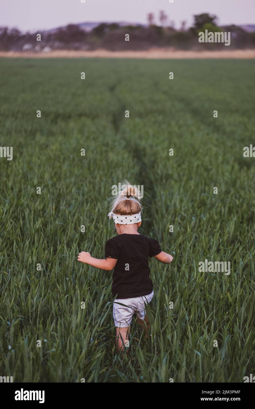A cute girl playing in an agricultural field Stock Photo - Alamy