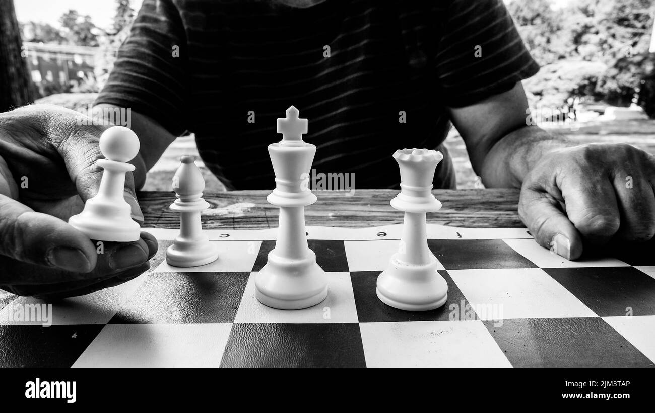 Man is playing chess with hat on head Stock Photo