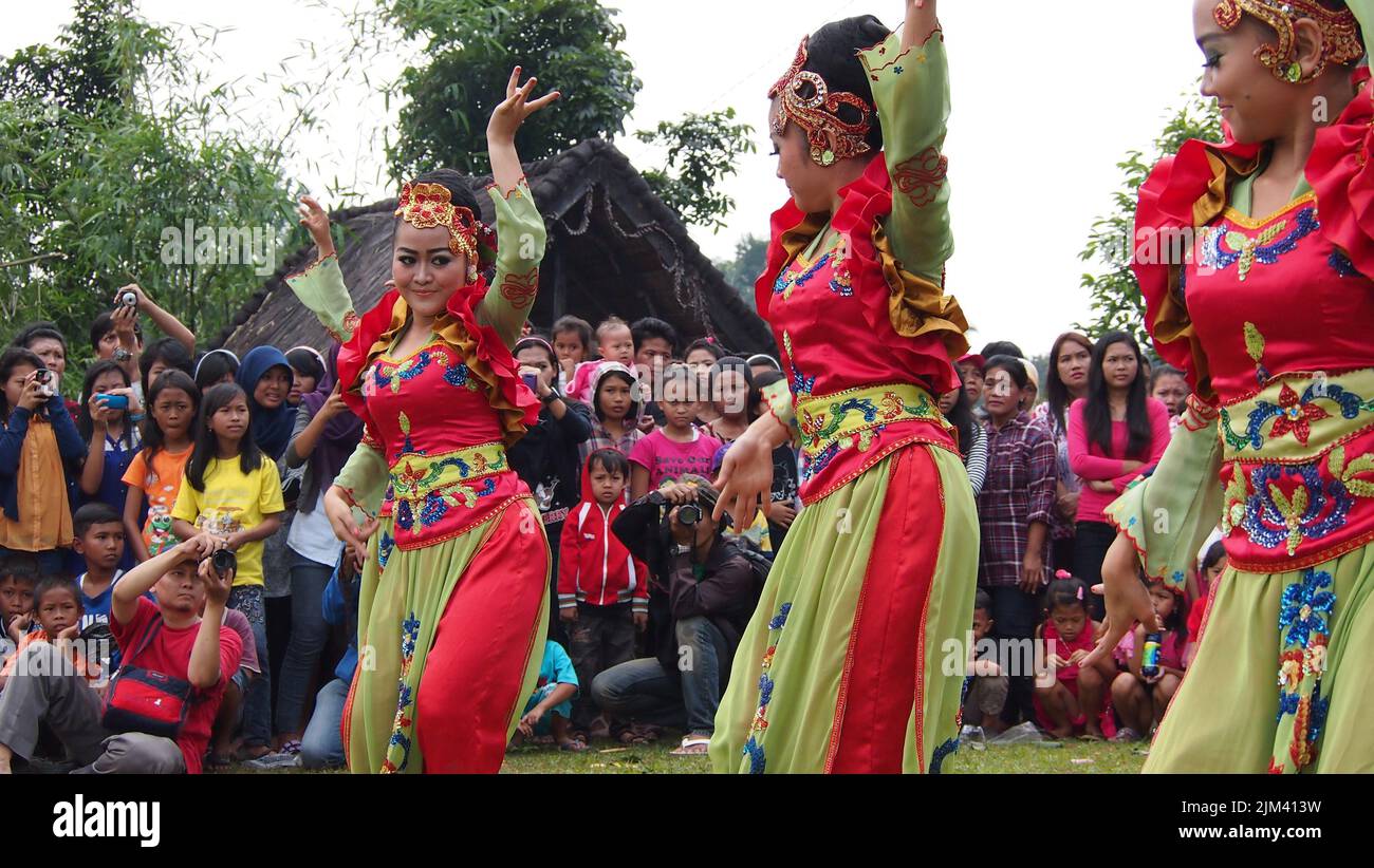 The three young girls dancing on a traditional folk culture ceremony in West Java, Indonesia Stock Photo