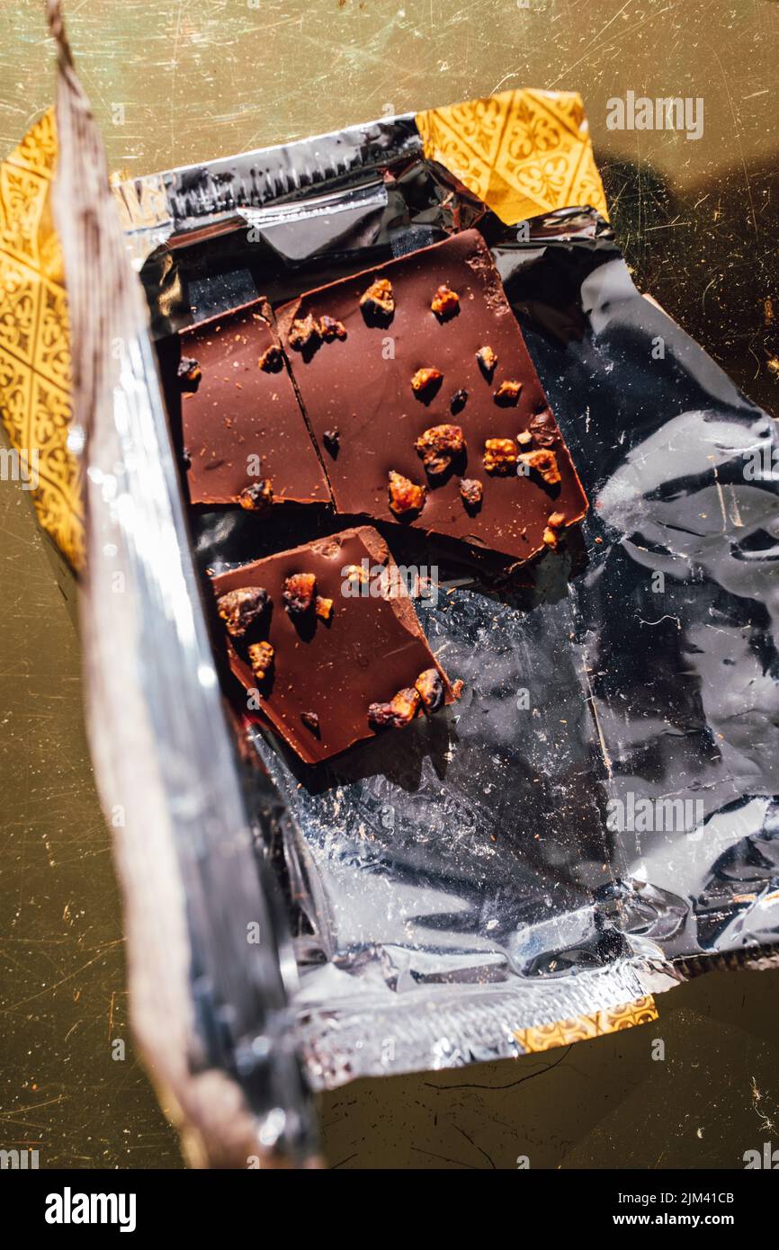 half eaten Gourmet chocolate bar in metallic gold and silver foil ...