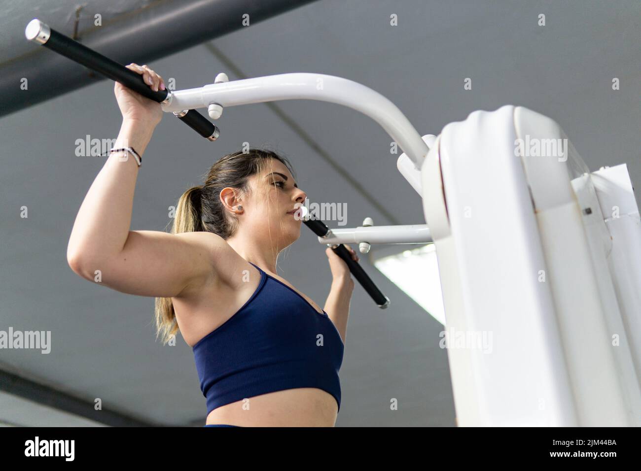 Young caucasian woman doing push ups in the gym. Lifestyle, workout ...