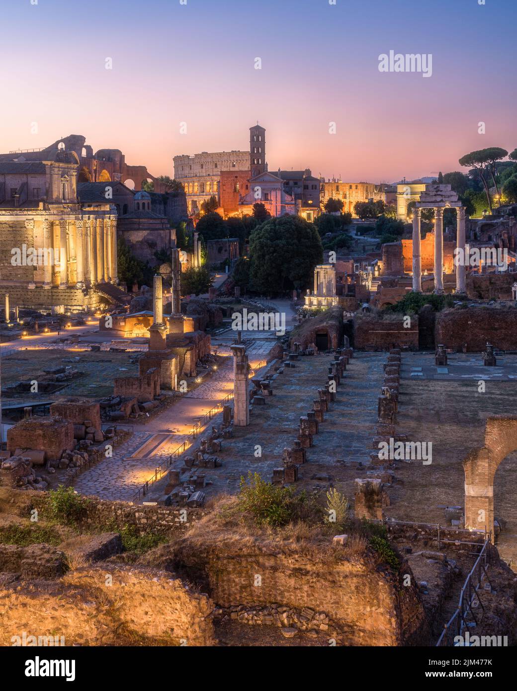 Scenic sight in the Roman Forum with the Colosseum at dawn. Rome, Italy. Stock Photo