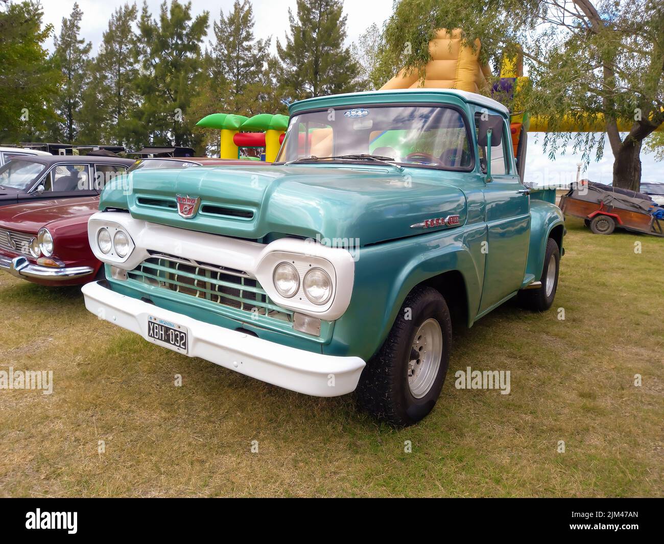 Old aqua utility pickup truck Ford F 100 Flareside bed third generation 1960. Nature grass trees. Classic car show. Copyspace Stock Photo