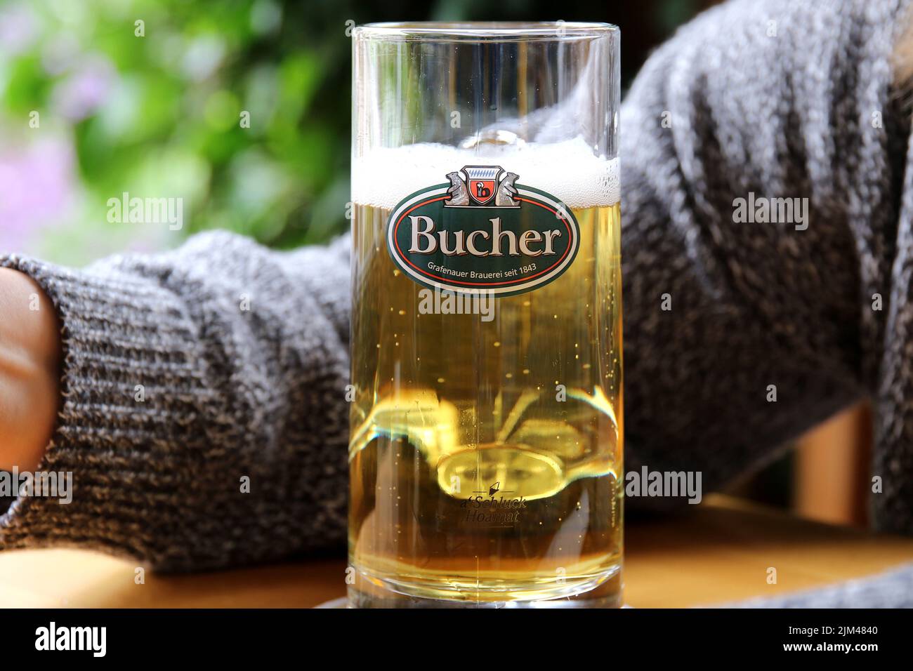 bucher is a beer brand from grafenau in bavariaa person's arm can be seen in the background Stock Photo