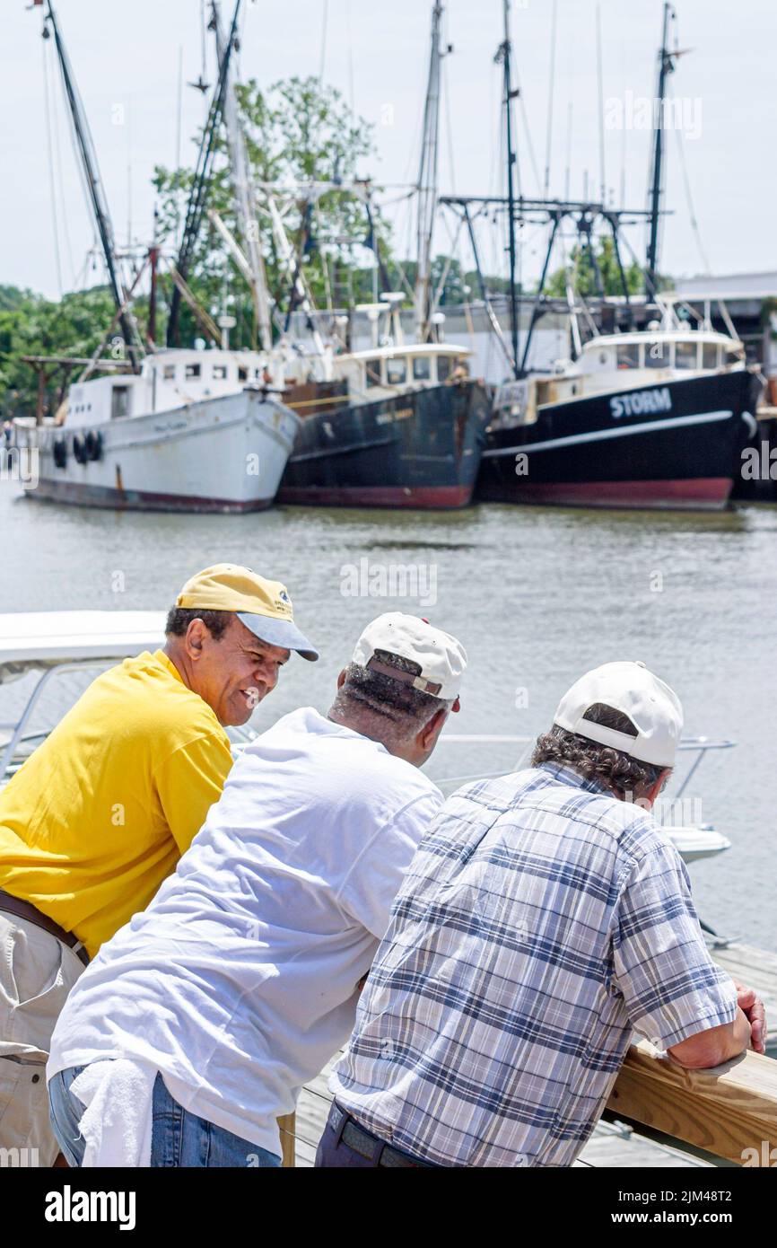 Hampton Virginia,Tidewater Area,Hampton River Herberts Creek water commerical fishing shrimping boats marina,Black man men friends scene in a photo Stock Photo