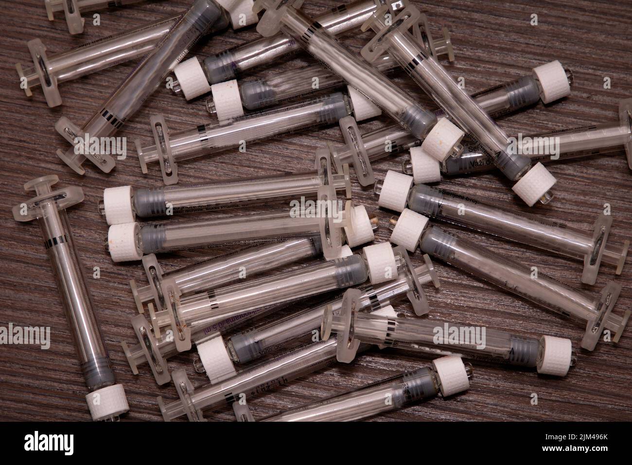 Pile of empty plastic syringes used medical waste disposal Stock Photo