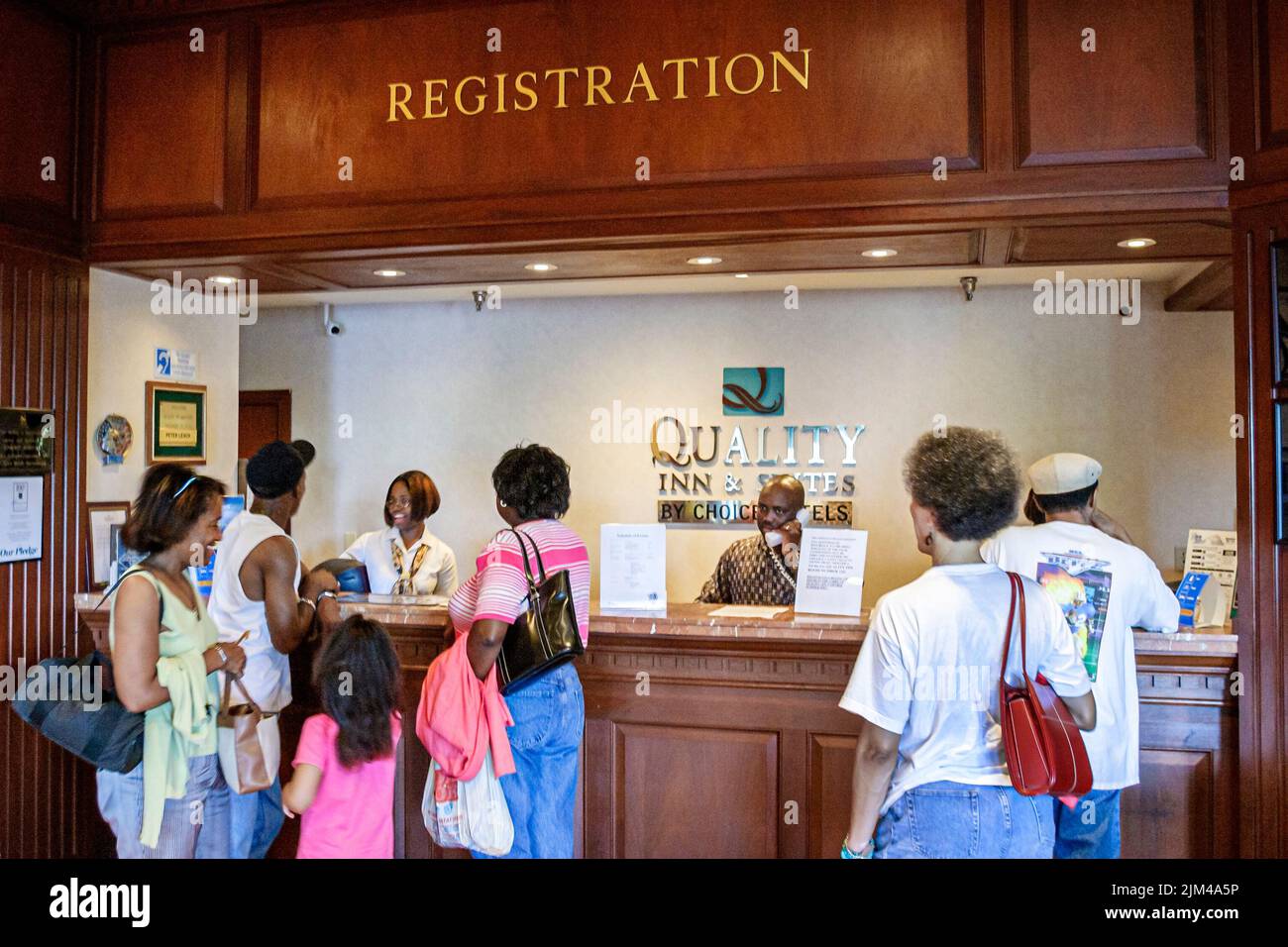 Hampton Virginia,Tidewater Area,Quality Inn & Suites hotel hotels lodging lobby front desk reservation registration Black families guests checking in Stock Photo